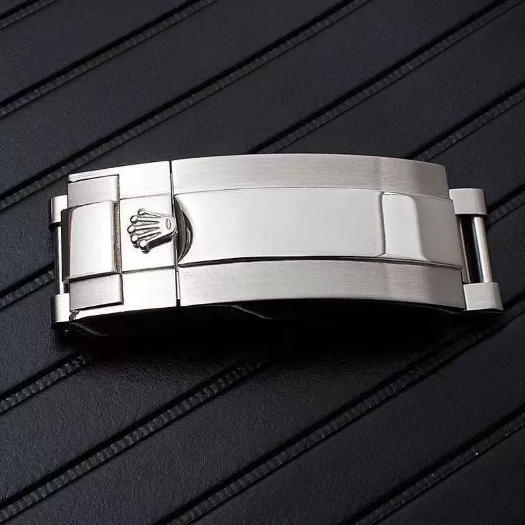 Brushed stainless steel clasp cover with raised crown logo, close-up